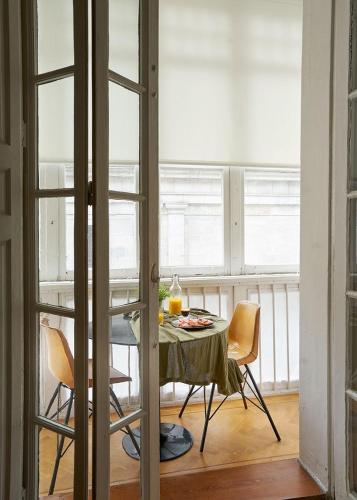 a table and chairs in a room with windows at Urban Suite Santander in Santander
