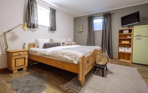 a bedroom with a large bed and a television at Höllwarts Appartements in Sankt Johann im Pongau