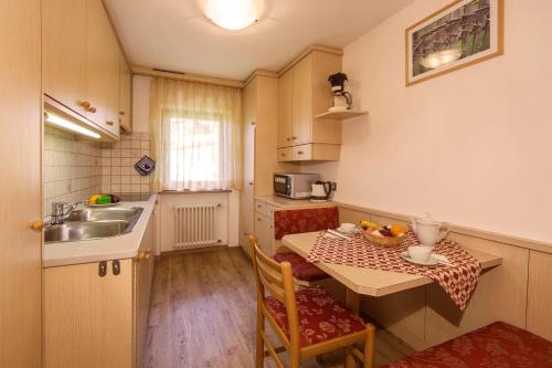 a small kitchen with a table and a sink at Appartamento Puez in Selva di Val Gardena