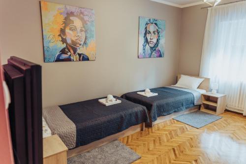 een kamer met 2 bedden en een schilderij aan de muur bij DuMalux Velvet in Subotica