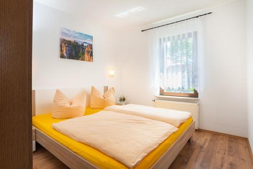 a bedroom with a yellow bed with a window at 4-Bettzimmer Sächsische Schweiz in Mittelndorf