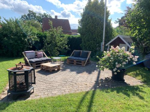 a patio with two chairs and a table and flowers at Comfortable Large Room King S bed near CPH centre in Copenhagen