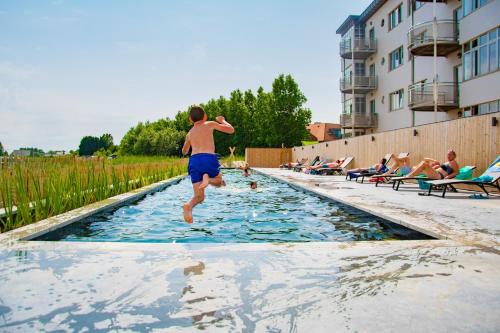 Un homme sautant dans une piscine dans l'établissement West Bay, à Westende