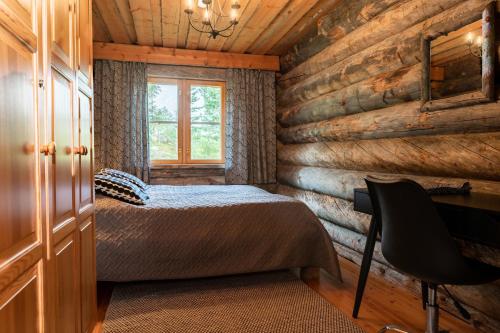 a bedroom in a log cabin with a bed and a desk at Ruska-Ruka 9.1 in Ruka