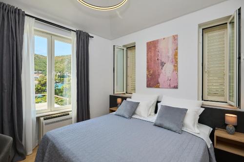 a bedroom with a bed and two windows at Hedera Estate, Villa Hedera III in Zaton
