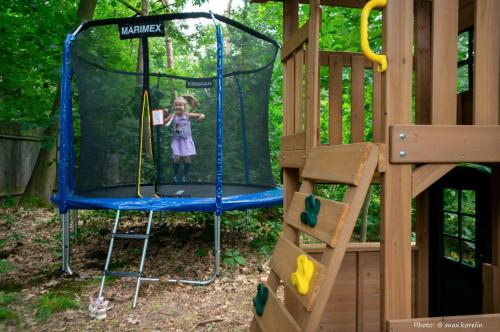 a little girl playing on a trampoline in a playground at Penzion Kersko in Hradišťko