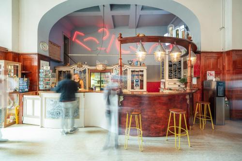 a group of people standing at a bar in a store at Three Little Pigs Hostel - Your Berlin Castle in Berlin