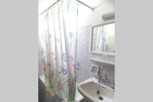een badkamer met een douchegordijn met bloemen erop bij Katerinas House Apartment in Agios Gordios