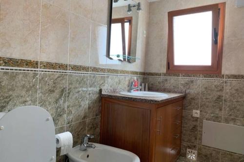 ein Badezimmer mit Waschbecken, Toilette und Spiegel in der Unterkunft Casa Da Villa in Vila Praia de Âncora