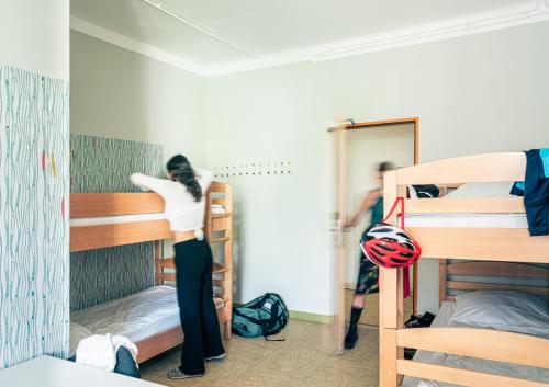 a bedroom with a bunk bed and a desk at Three Little Pigs Hostel - Your Berlin Castle in Berlin