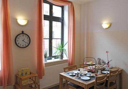 a dining room with a table and a clock on the wall at Hotel Waren-Alte Warener Zeitung in Waren