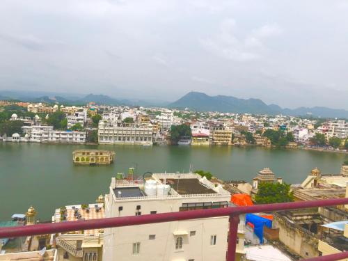 a view of a city and a body of water at Peacock Guest House - Lake View Hotel In Udaipur in Udaipur