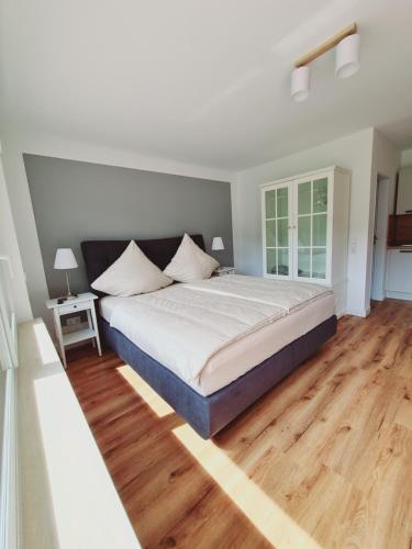 a bedroom with a large bed and a wooden floor at Moseltraum in Traben-Trarbach
