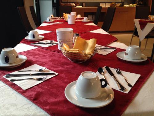 a table with a red and white table cloth with silverware at Villa Regina in Riva del Garda