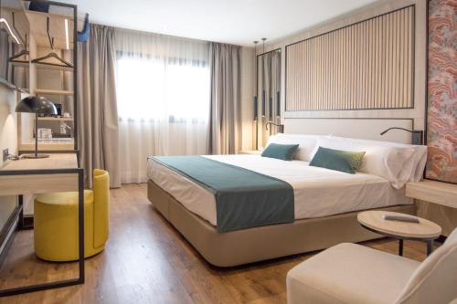 a bedroom with a large bed and a room with a couch at Soho Boutique Córdoba in Córdoba