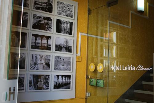 una habitación con fotos en la pared y una puerta de cristal en Hotel Leiria Classic, en Leiria