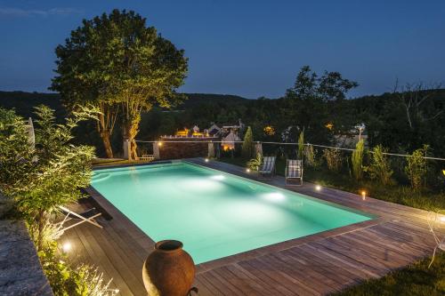 a swimming pool with a wooden deck at Le Domaine des Carriers in Chevroches