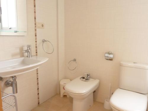 La salle de bains est pourvue de toilettes blanches et d'un lavabo. dans l'établissement Apartamentos Boutique Pompeya, à Peñíscola