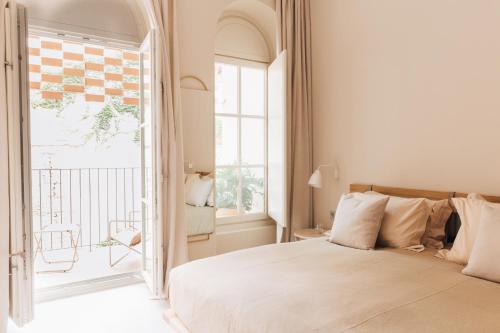 a bedroom with a bed and a large window at Plácido y Grata in Seville
