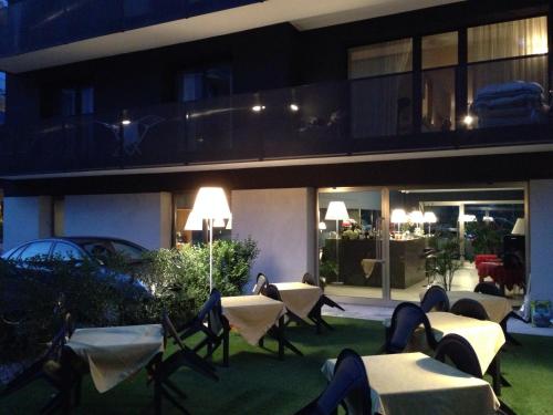 a building with tables and chairs in front of it at night at Villa Regina in Riva del Garda