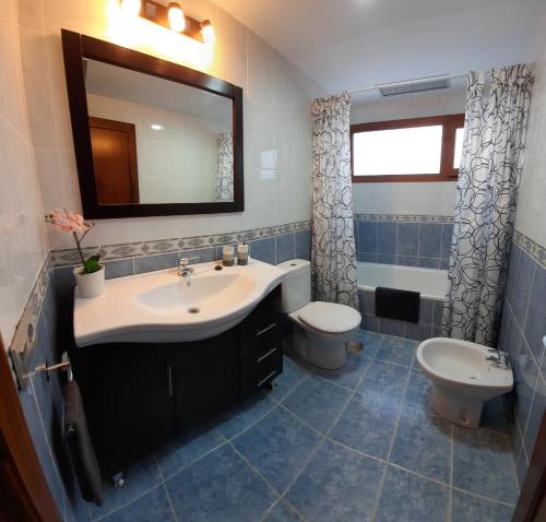 a bathroom with a sink and a toilet and a mirror at CASA MONTES in Playa Blanca
