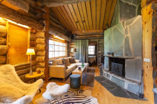 a living room with a fireplace in a log cabin at Kuukkeli Log Houses Teerenpesä - Premium Suite A48 in Saariselka