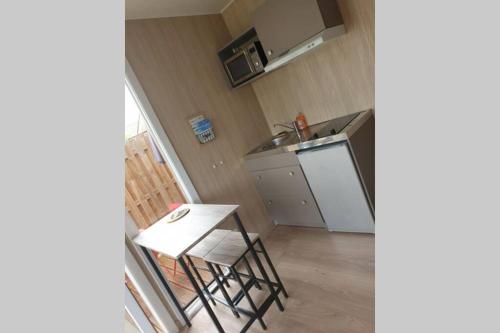 une petite cuisine avec une table et un évier dans l'établissement Lou cabanot, à Sanguinet