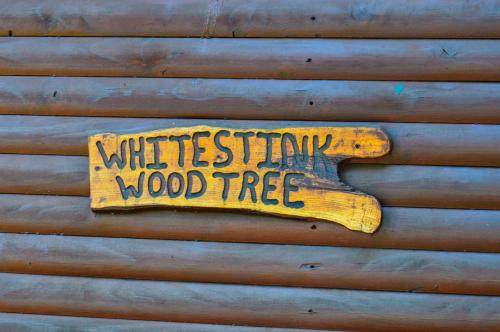a wooden sign on the side of a wood tree at Stone Hill in Magaliesburg