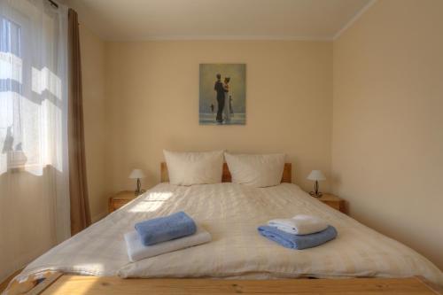 1 dormitorio con 1 cama con 2 toallas en Ferienwohnungen Strandvilla Börgerende, en Börgerende-Rethwisch