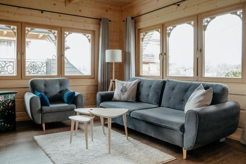 a living room with a couch and two chairs and a table at Osada Witów - dom „Dziewięćsił” in Witów