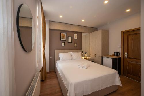 a bedroom with a white bed and a mirror at TAKSİM SUİTE in Istanbul
