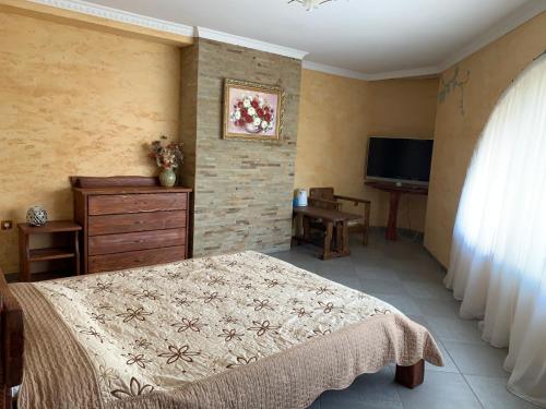 a bedroom with a bed and a dresser and a television at Polyanskiy Zamok in Polyana