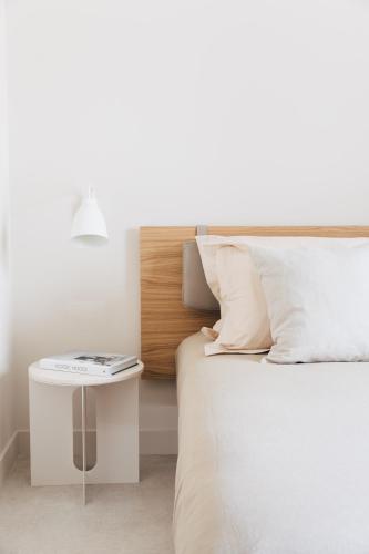 a bed with a night stand next to a bed with a white bedspread at Plácido y Grata in Seville
