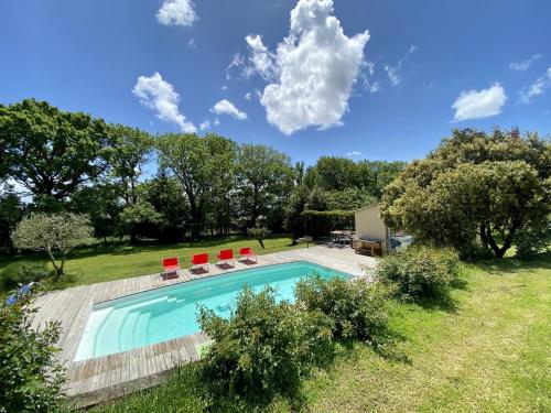 - une piscine dans une cour avec des chaises rouges dans l'établissement Borie Grande, à Saint-Denis