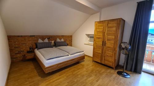 a bedroom with a bed and a brick wall at Bunter Hirsch Ferienwohnung im Garmischer Zentrum in Garmisch-Partenkirchen
