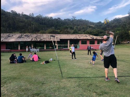 a group of people playing with a kite in a field at Espaço Casa na Rocha in São José dos Campos