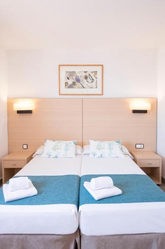 two beds sitting next to each other in a room at Apartaments Cye Salou in Salou