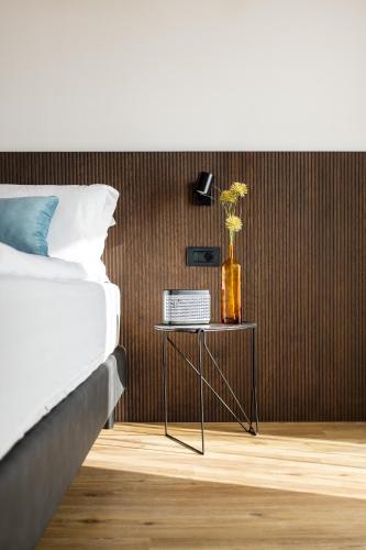 a bedroom with a bed and a table with a vase at VistaLago Torbole in Nago-Torbole