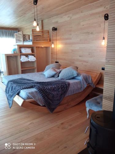 a bedroom with a bed in a wooden wall at cabañas en el árbol costa da morte in Muxia