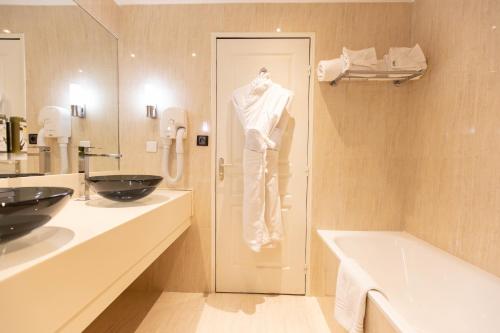 a bathroom with a white towel hanging on the wall at Mouratoglou Hotel & Resort in Biot