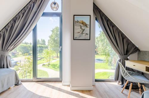 een slaapkamer met een bed en een groot raam bij Domki w Naturze in Lubiatowo