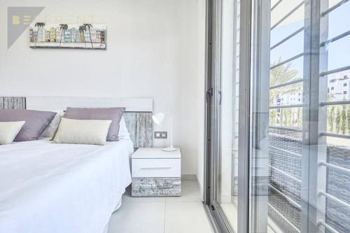een witte slaapkamer met een bed en een raam bij Beferent Los Arenales playa in Arenales del Sol