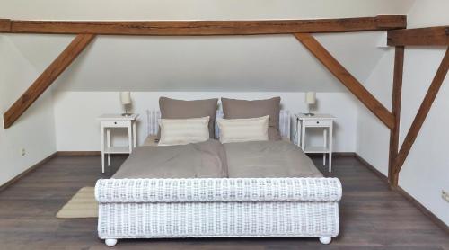 a bedroom with a white bed and two tables at Ferienwohnungen in ausgebauter Scheune mit Ostseenähe in Zarnekow