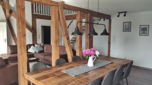 ein Esstisch mit einer Vase mit Blumen darauf in der Unterkunft Ferienwohnungen in ausgebauter Scheune mit Ostseenähe in Zarnekow