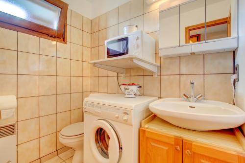 une salle de bain avec une machine à laver et un lavabo dans l'établissement Corniche A4, à Morzine