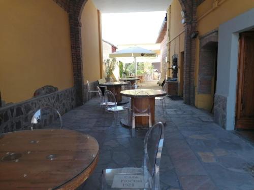 HOTEL FIORE & Fiocchi في Podenzano: فناء به طاولات وكراسي ومظلة