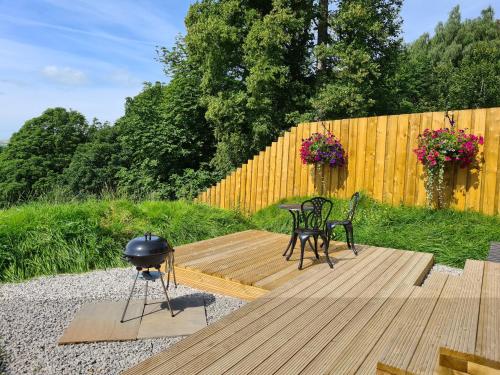 a patio with a bbq and two chairs and a grill at Peak District Shepherds Hut in Hope