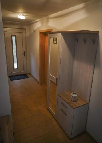 a small kitchen with a refrigerator and a hallway at Fewo Hellerswiesen Arbeiterunterkunft in Bahretal