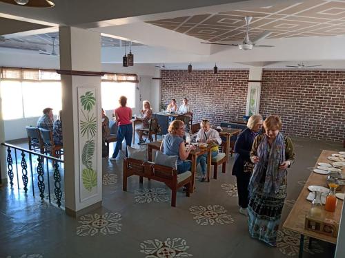 een groep mensen die aan tafel zitten in een restaurant bij Lakeside Inn Ratanada in Jodhpur