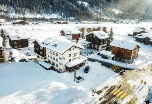 eine Luftansicht eines Resorts im Schnee in der Unterkunft Hotel Alpina in Ulrichen